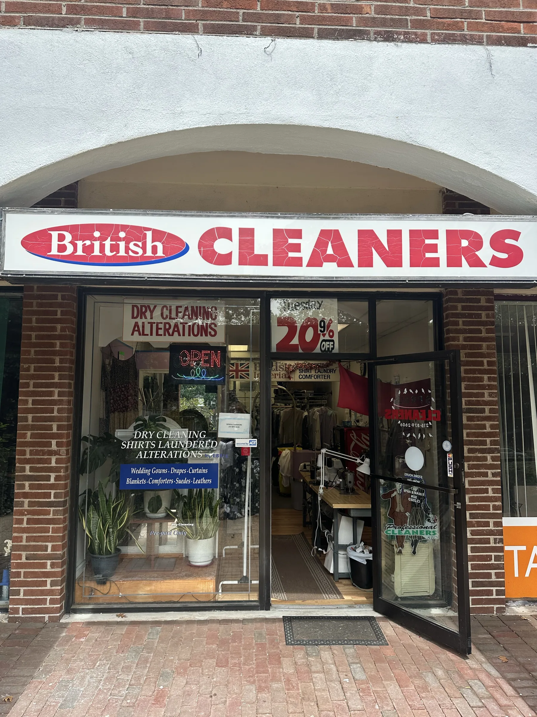 Sproul Cleaners storefront beneath the British Cleaners sign, with the front door open.